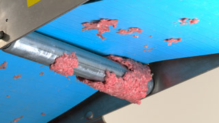 Ground beef sticking on conveyor belt and falling to floor